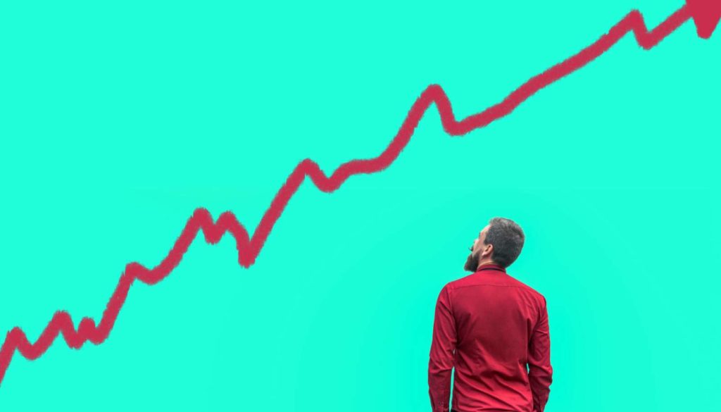 a man looking at a red arrow pointed up