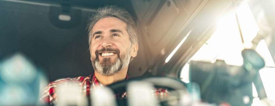 Photo of man in drivers seat of tractor trailer